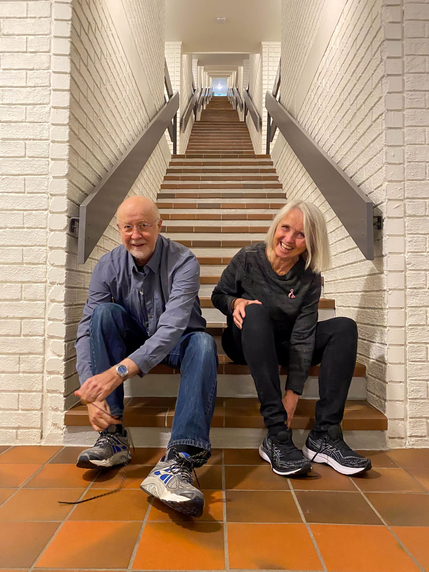 Paul og Anne sitter i trappa og knyter på seg skoene, klare til å ta fatt på de 192 trappetrinnene.