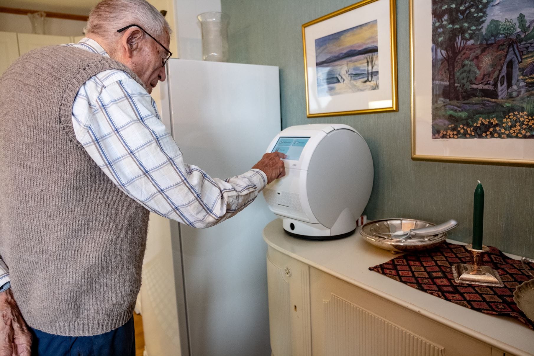 En gammel mann trykker på multidose-dispenser for å få medisinen sin