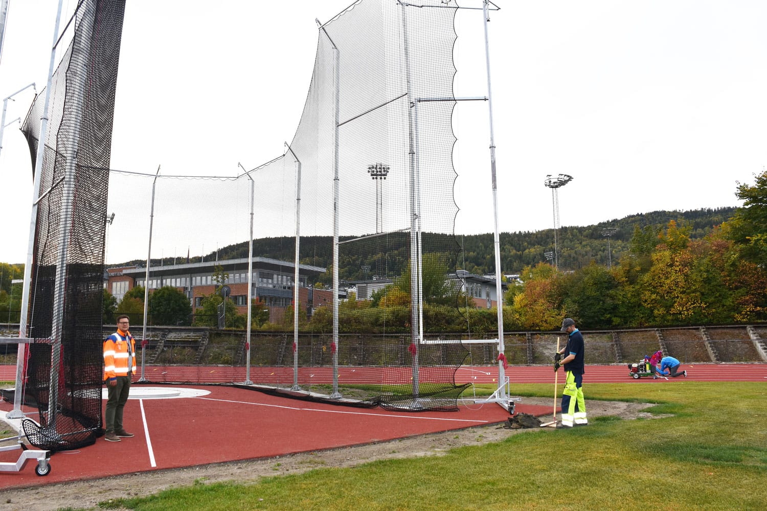 Friidrettsstadion med ny kastbu. Prosjektleder Erik Udnæs  viser høyden.