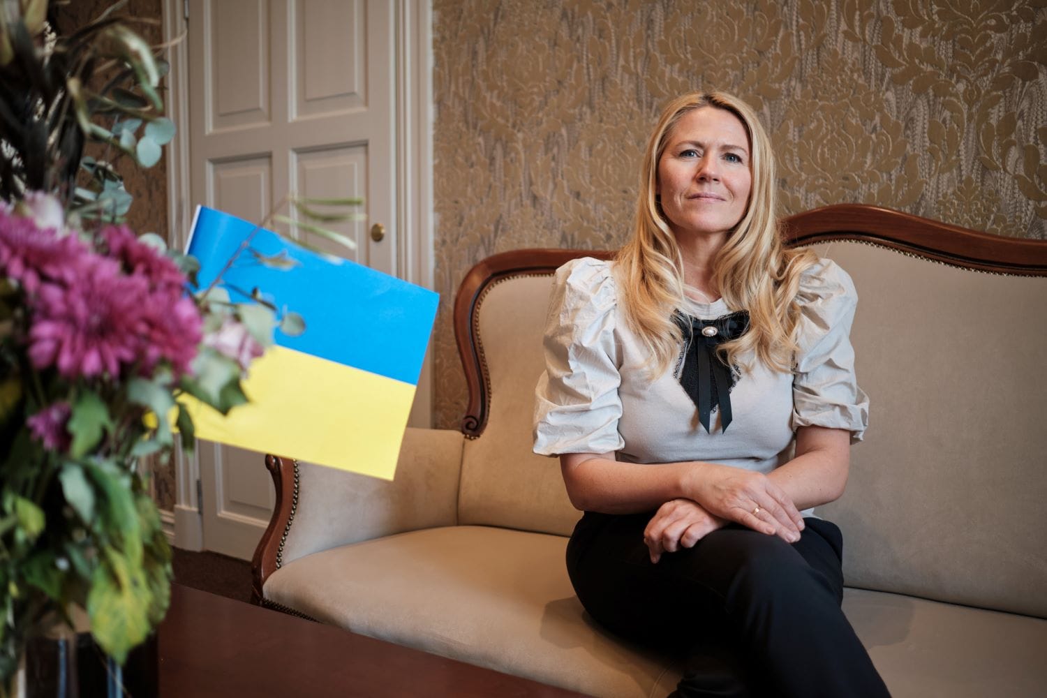 Monica Myrvold Brg i sofaen på kontoret hennes. Foran har hun en blomst med ukraina-flagg oppi.