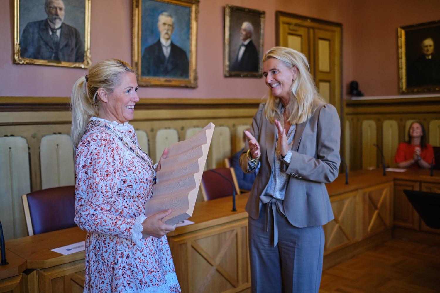 Monica Myrvold Berg mottar en keramikkplankett fra Cathrine Pia Lund i formannskapssalen i rådhuset.