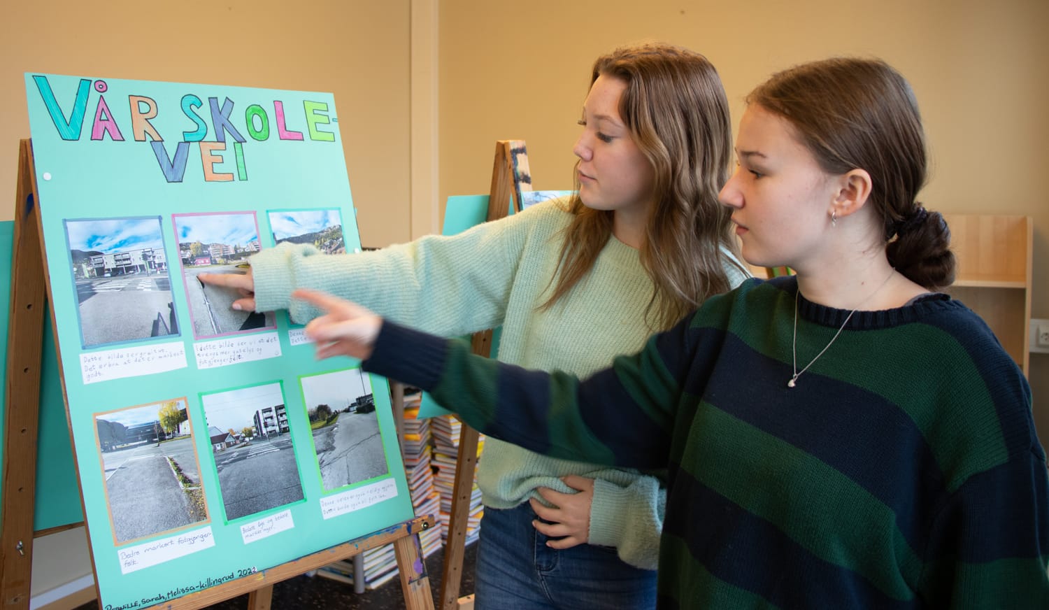 To elever peker på plakaten de har laget og forklarer hva de har tenkt når de har analysert sin egen skolevei.