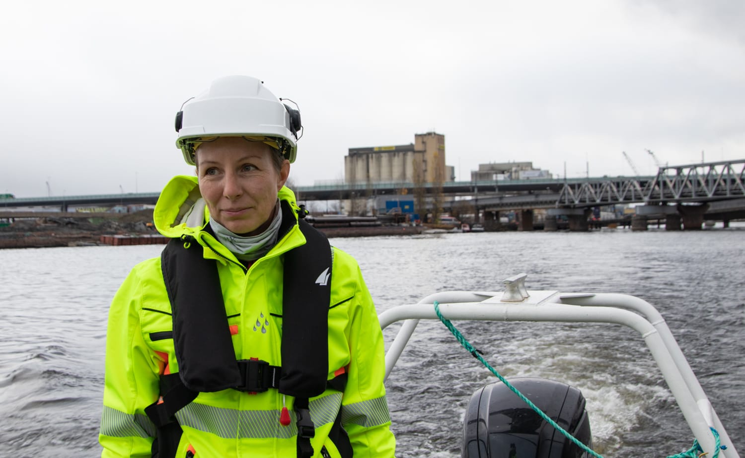 Prosjektleder for Bybrua, Maria Algers Bakken, i båt på vei mot anleggsområdet i gul vernedrakt med hvit hjelm.