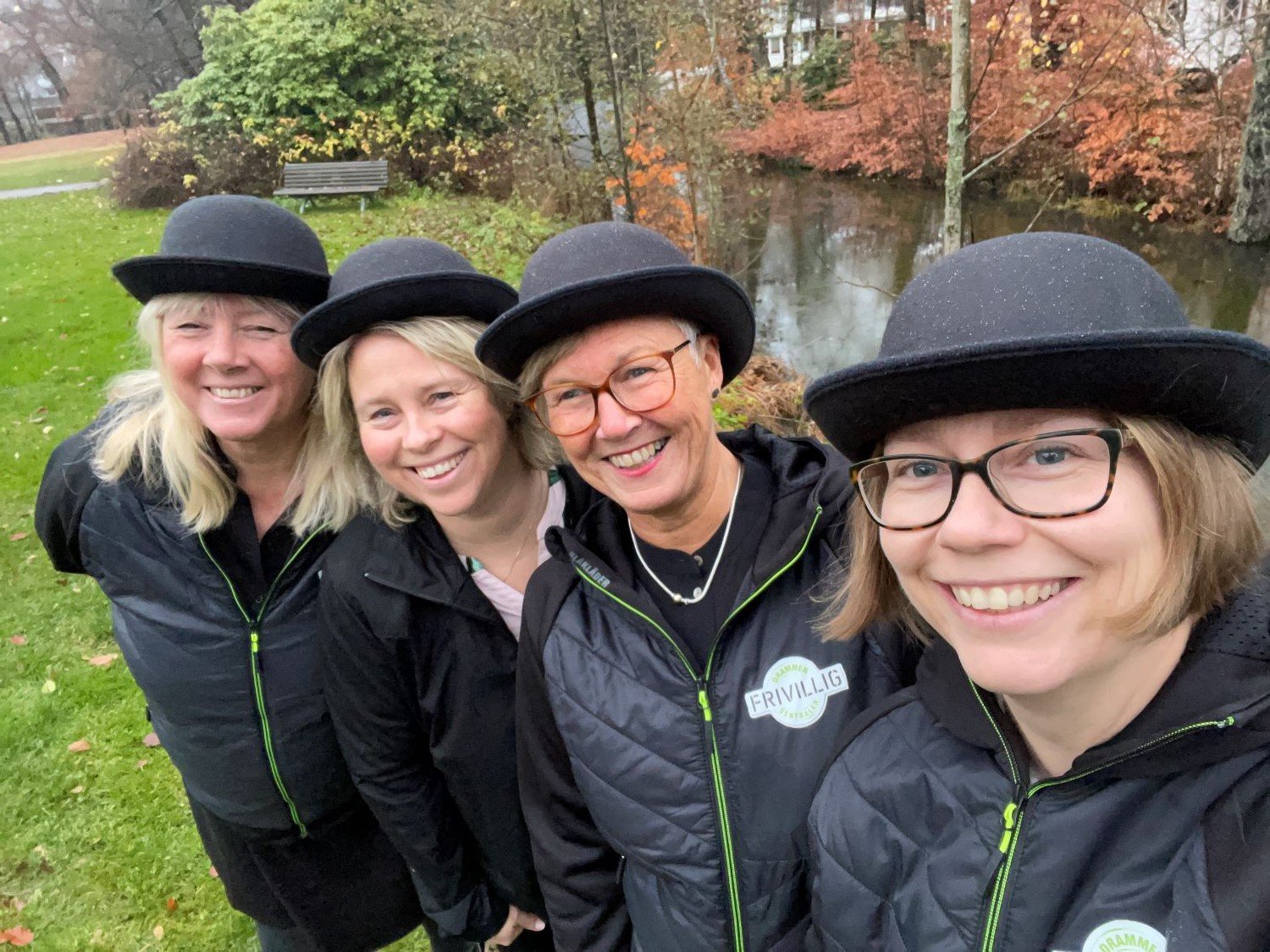 Fire damer med svarte  bowler-hatter står ved siden av hverandre på en linje