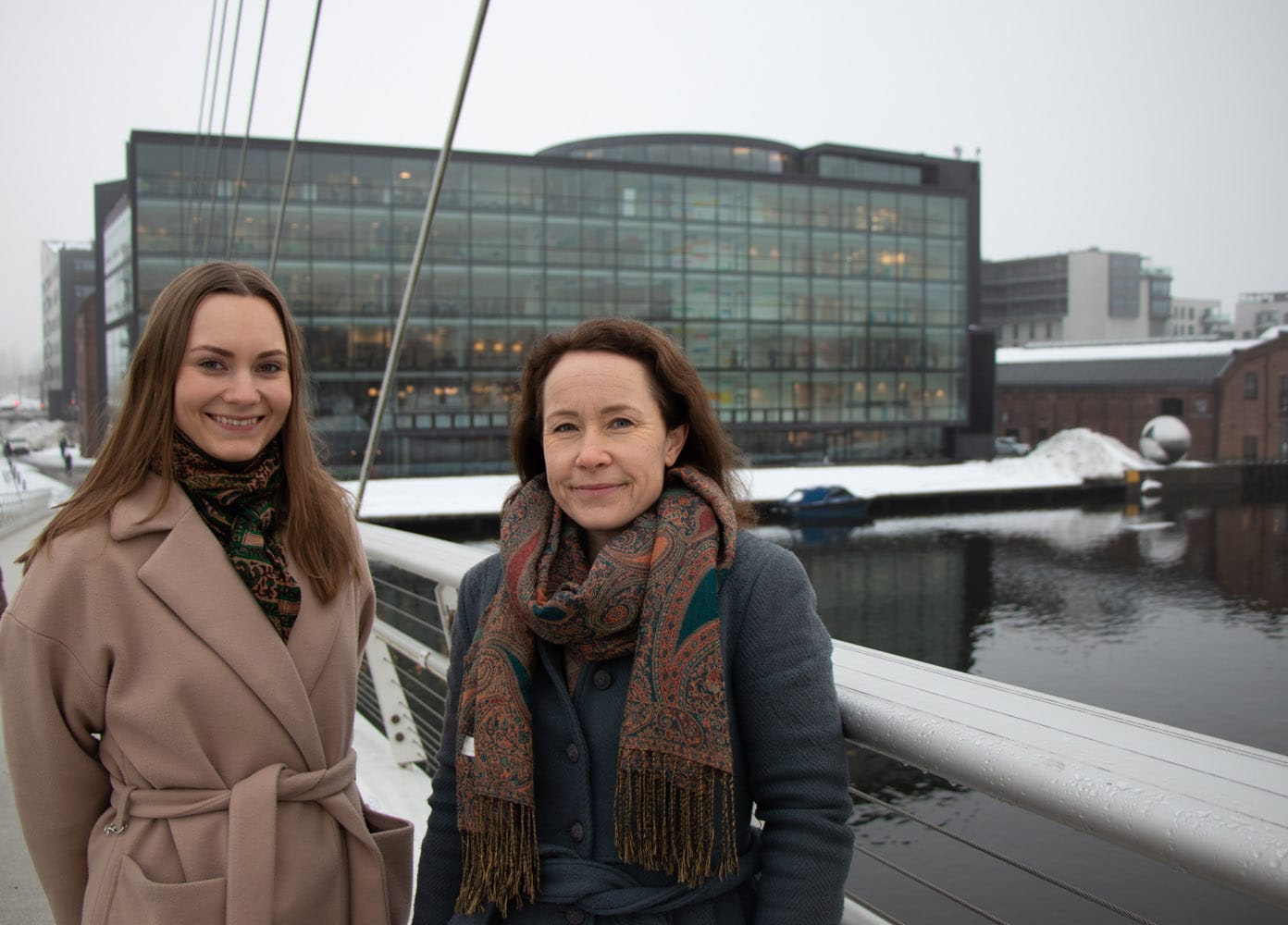 Klimarådgiverne Ingebjørg Weselka Tofte og Oda Bjørnnes står på Ypilon med biblioteket i bakgrunnen