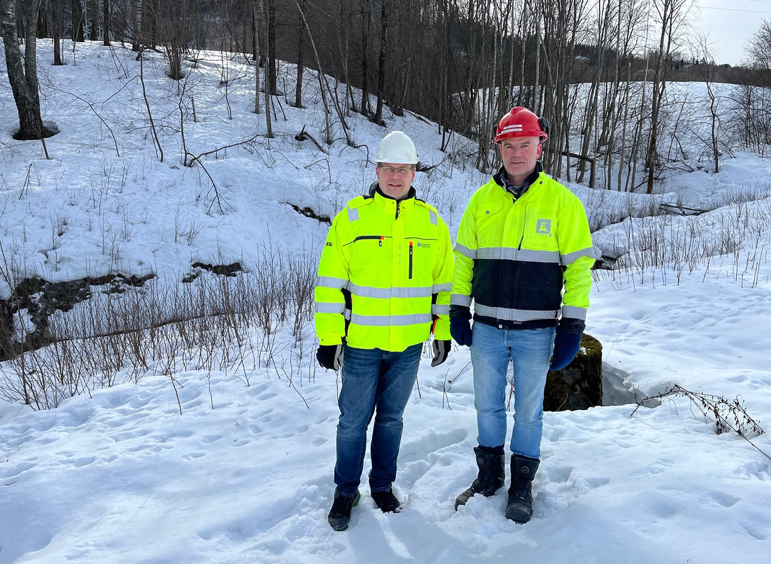 Prosjektlederne Udnæs og Leirvik står ved siden av Vrangbekk. Bakken er dekket av snø.