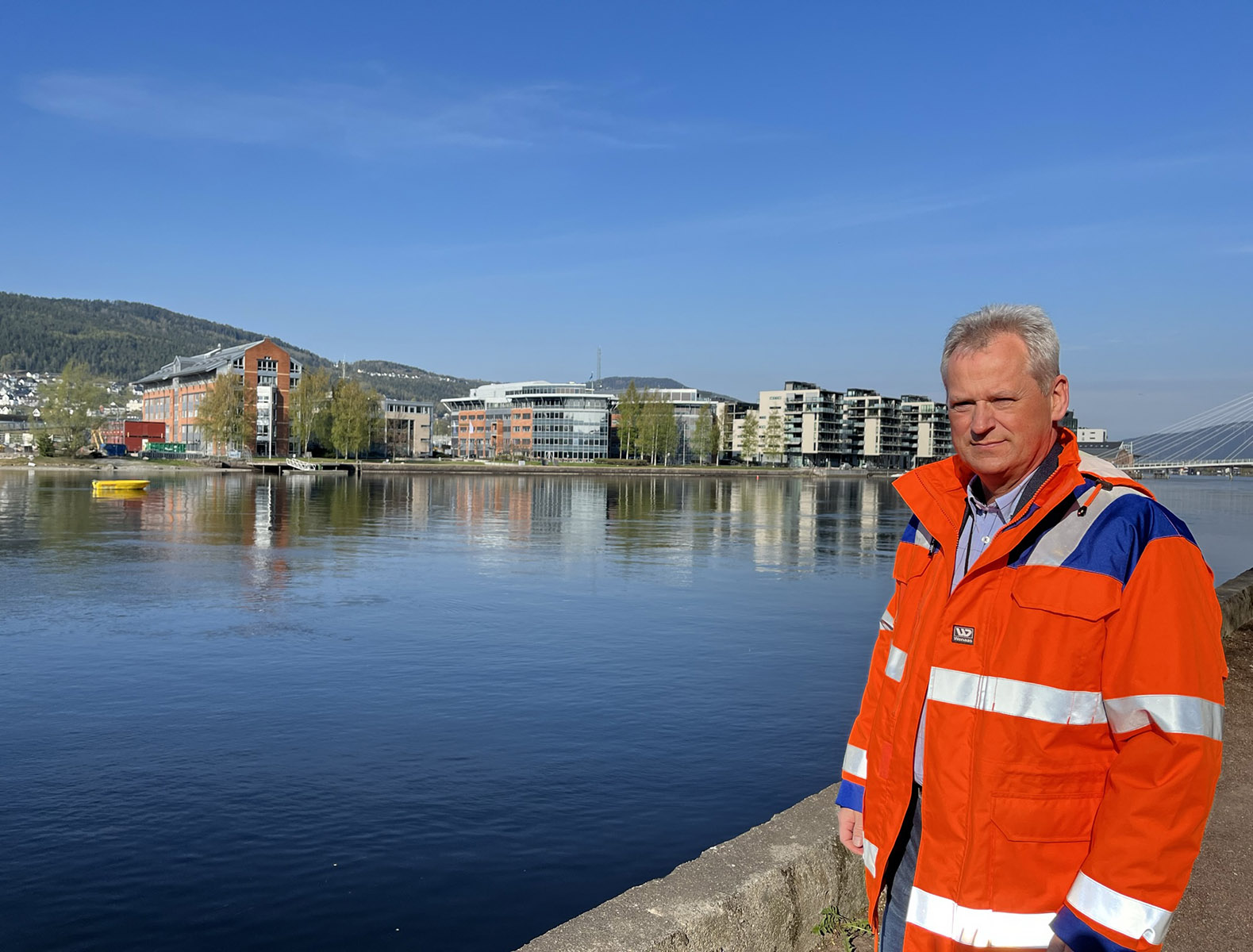 Beredskapssjef Sten Petter Aamodt står ved Drammenselva med Union brygge i bakgrunnen