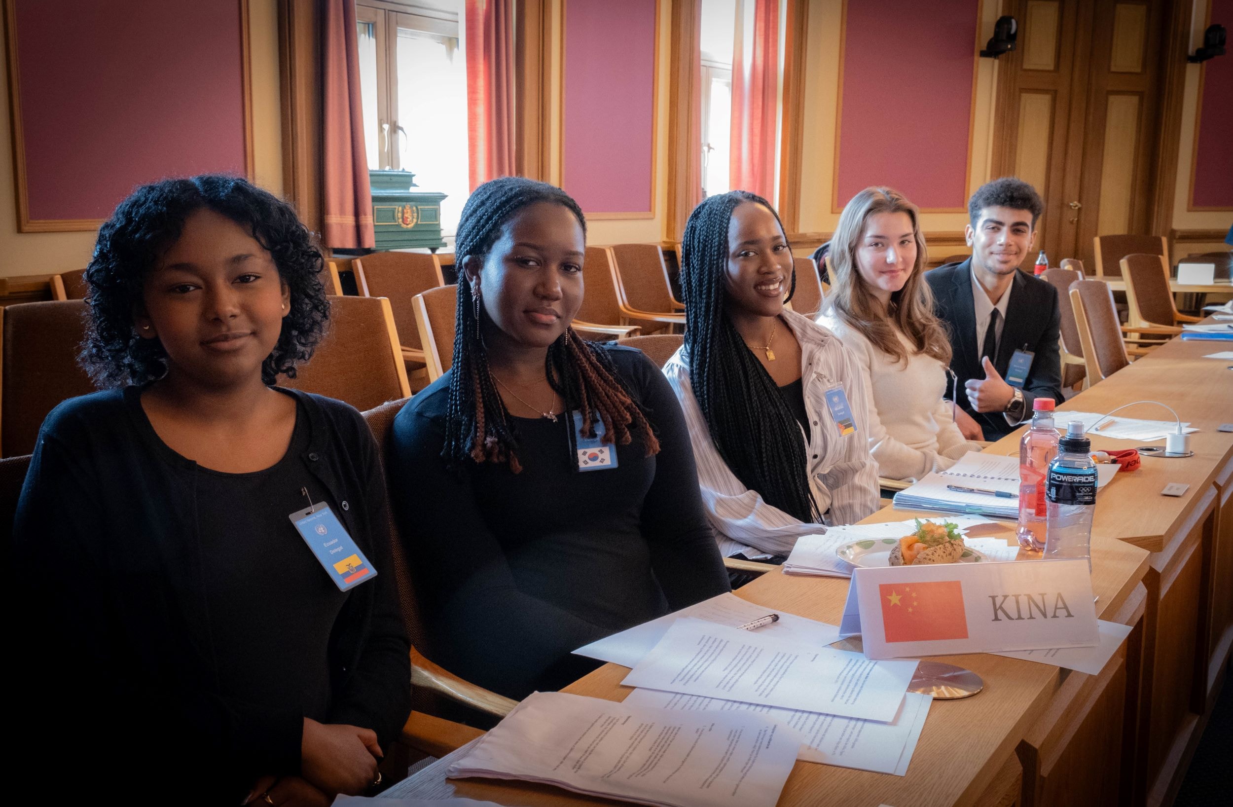 Mary Tessmeko, Qestia Ishimwe, Fina Mariana Koroma, Hanna Sawczyn og Yousef El-athamna sitter på rad i kommunestyresalen i rådhuset i Drammen.
