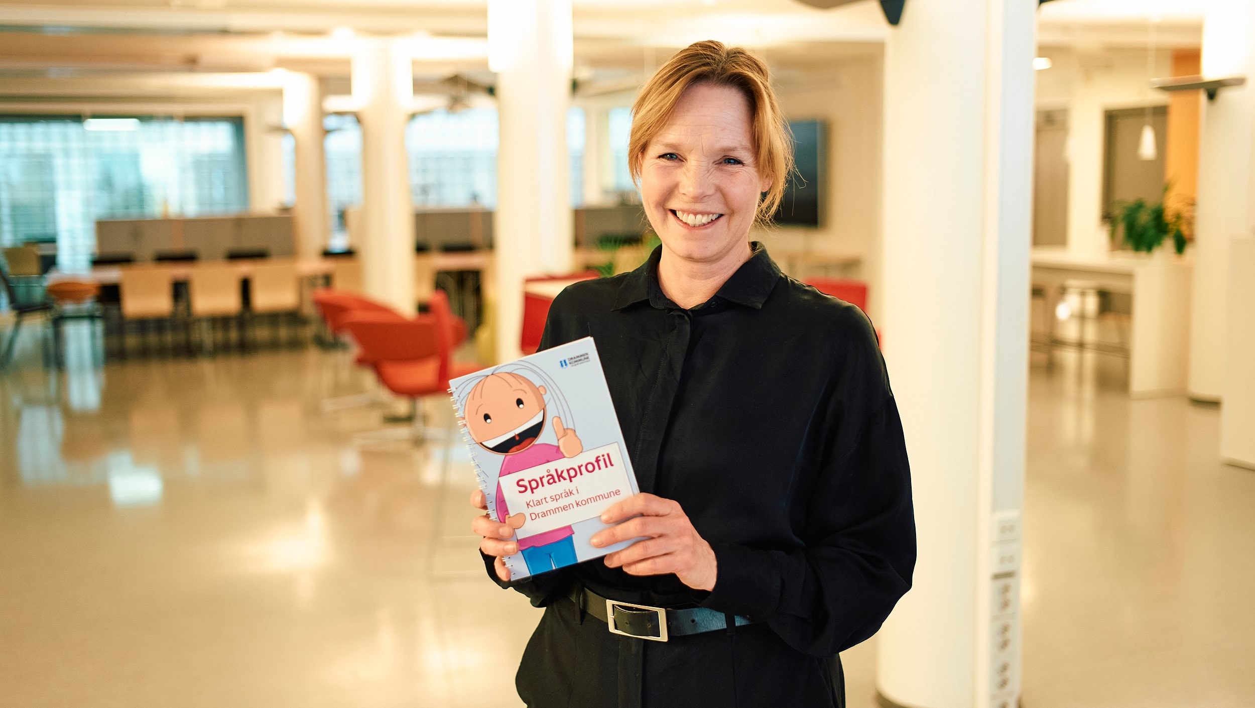 Trude Andresen holder et eksemplar av språkprofilen Klart språk i Drammen kommune å hånda