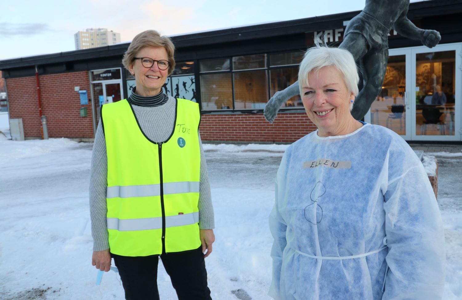 to pensjonister som jobber med vaksinering utenfor Drammenshallen