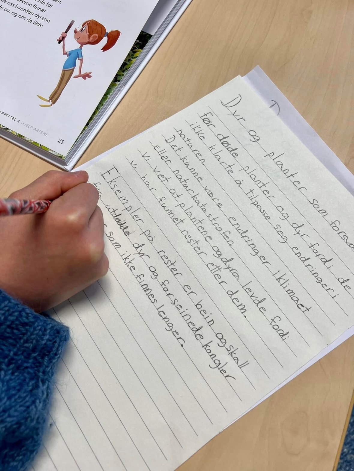 Et bilde som viser at en elev skriver tekst for hånd.