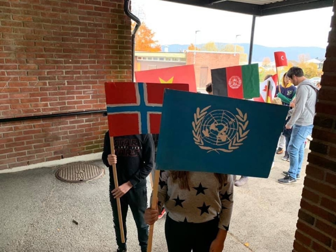 Elever marsjerer med ulike flagg