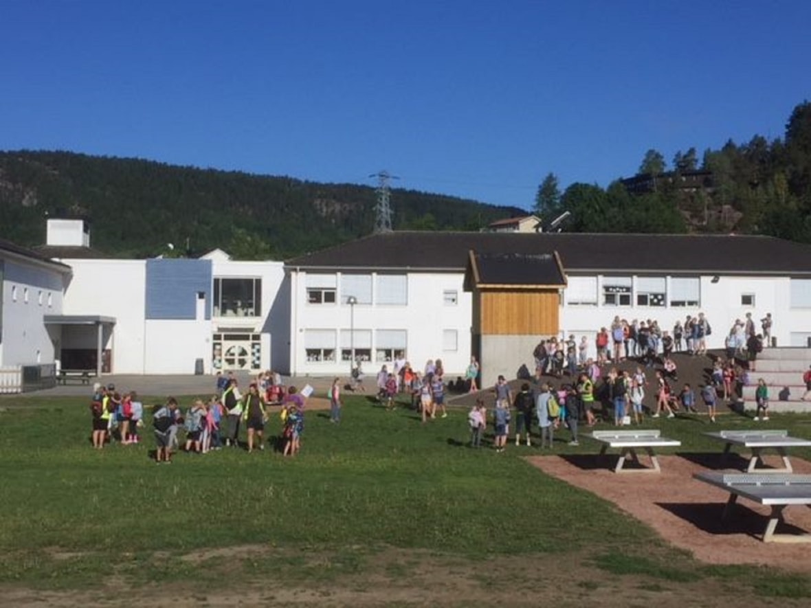 Elever leker i skolegården på sommeren